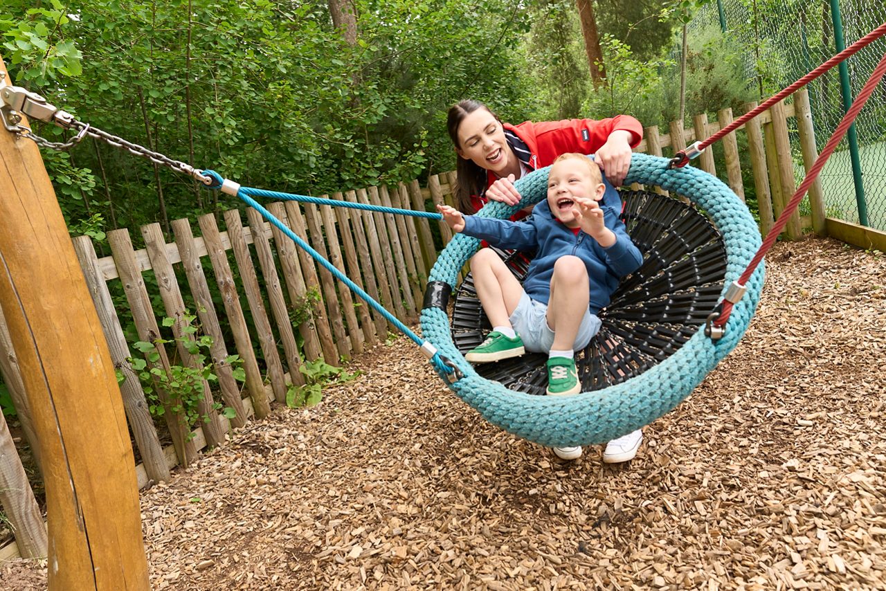 Mum and child playing in outdoor play area.